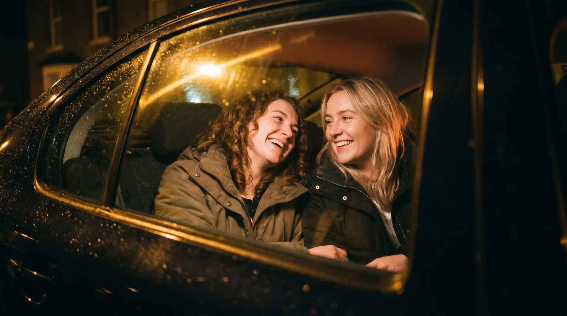 Friends sharing the back seat of a Wednesfield Cars taxi, laughing on a night out across Wolverhampton